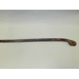 A South East Asian carved cane walking stick the pommel carved as a mythical beast