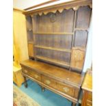A late 19th century/early 20th century oak and mahogany crossbanded dresser with shaped canopy and