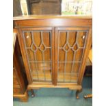 A simulated walnut free standing bookcase with leaded glass doors on squat cabriole legs, 80cm wide,