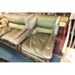 A Jacobean style three piece lounge suite comprising wing back two seater green upholstered settee