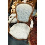 A pair of Louis XV style walnut famed panel back open armchairs on short cabriole legs and castors