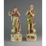 A pair of early 20th century Royal Dux figures of a shepherd and female goatherd,
