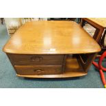 An Ercol elm 'Pandora's box' coffee table with an openwork shelf and two short drawers raised on