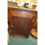 An early 19th century oak and elm straight front wall hanging corner cabinet the panel door