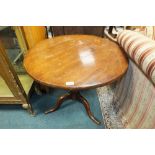 A 19th century fruit wood tilt top tripod table on pilaster column and three down curved legs,