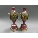 A pair of Vienna porcelain vases of amphora shape on pedestal bases and painted in colours with