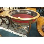 An Edwardian mahogany and inlaid oval bijouterie table with glazed top and sides and lined interior