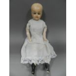 A late 19th century wax headed doll with painted composite limbs and contemporary lace trimmed