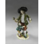 A Continental porcelain figure group of a rustic man with young boy holding flowers