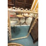 A large wall mirror in gold coloured open foliate frame