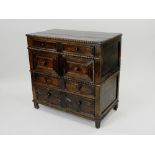 A late 17th century joined oak chest of four long drawers the three plank top with half bobbin