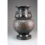 A large Chinese bronze vase, late Qing Dynasty, of baluster form with twin dragon head handles,