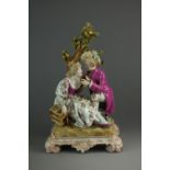 A Paris porcelain figural group of two lovers beside a tree, the female holding a birdcage,