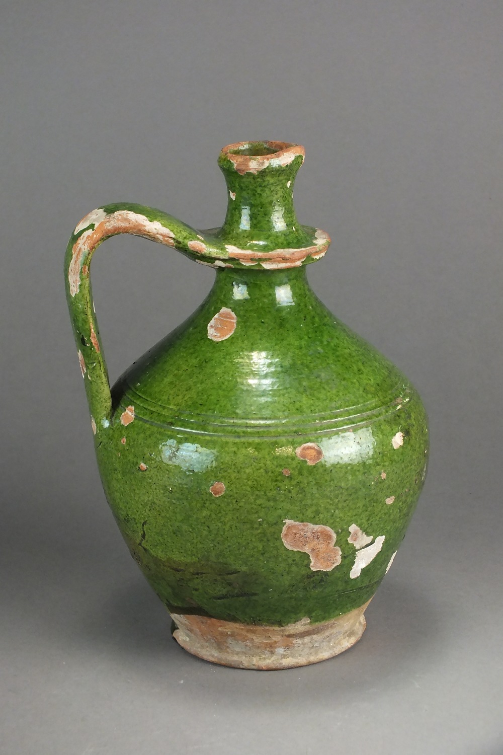 A medieval green glazed stoneware wine jug with single handle, 21.