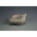 A Roman pottery lamp, circa 2nd Century AD, of compressed globular form with leaf moulded handle,