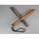 Two Victorian police truncheons, one painted oak the other plain, plain handles and shafts,