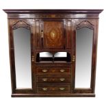 An Edwardian mahogany and inlaid bedroom suite comprising a triple wardrobe with classical mask and