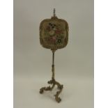 A gilt gesso and brass pole screen 19th century with floral tapestry work panel on an adjustable