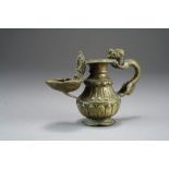 A Tibetan bronze lamp, 19th Century, of ovoid form with dragon handle and moulded 'spout' lantern,