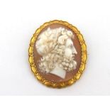 A Victorian shell cameo, the oval cameo depicting a Grecian bust in profile, within a gold mount (