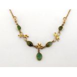 A green tourmaline necklace, the front set with spectacle set oval cabochon stones with foliate