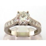 A fine diamond ring, the central brilliant approx. 1.1 carat, claw set above brilliant set shoulders