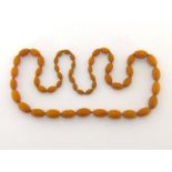 A reconstituted amber necklace, composed of graduated oval beads, 76gms