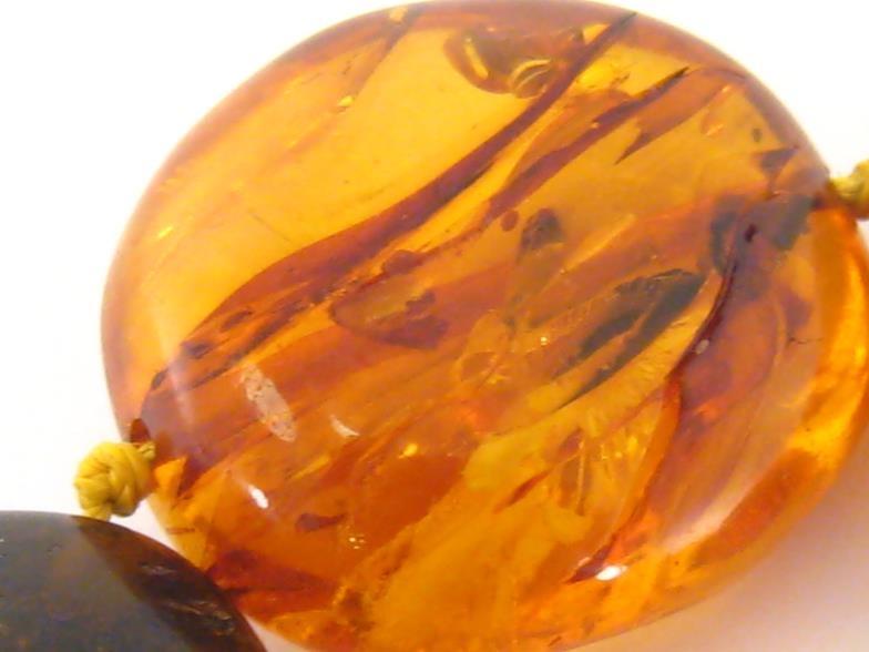 An amber necklace, composed of large polished flattened off round transparent and opaque beads, to a - Image 3 of 4