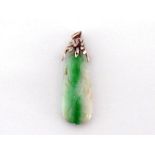 An Art Deco jade and diamond pendant, the oblong jade carved in the round with a fluid foliate