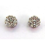 A pair of diamond daisy cluster ear studs, each cluster composed of seven small brilliants totalling