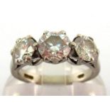 A three stone diamond ring, the central 1.00 carat claw set brilliant between two smaller