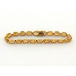 A citrine line bracelet, composed of uniform 7 x 5mm oval cut stones, to a box snap clasp,