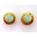 A pair of synthetic opal ear studs, the small rub over set stones 4mm diameter, stamped '14k',