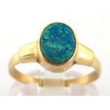 A synthetic opal ring, the oval tablet 9.6 x 7.3mm, rub over set, the shank stamped '585', finger