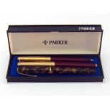 A Parker 61 fountain pen and ballpoint pen set, with gold plated cap and burgundy barrel,