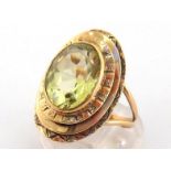 A 9 carat gold and citrine ring, the central oval cut stone 13.5 x 10mm, in a three tiered surround,