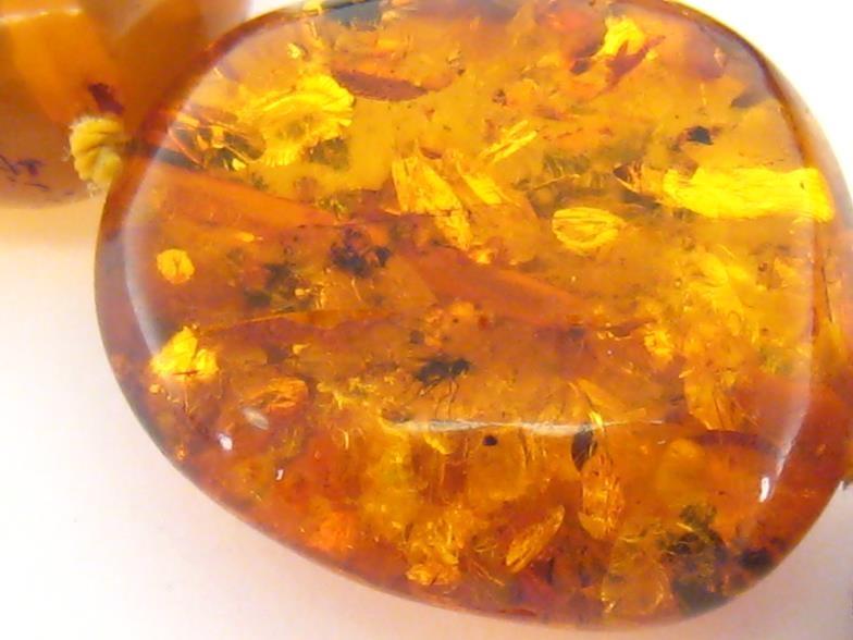 An amber necklace, composed of large polished flattened off round transparent and opaque beads, to a - Image 4 of 4