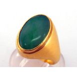 A jade ring, the oval jade tablet 14.5 x 9.5mm, rub over set, mounted in yellow metal (tests 18