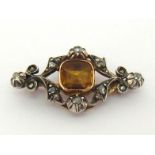 A late 19th century French topaz and diamond brooch, the central foil backed square cut yellow topaz