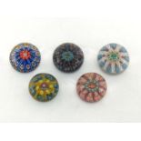 A group of five millefiori paperweights with latticino divisions, largest 8cm. across.