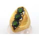 A green tourmaline ring, the three uniform 6mm round cut stones vertically set above shaped and
