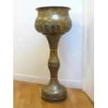 A large brass jardinière with rolled rim on tall conforming stand, all finely chased with shells,