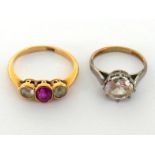 A synthetic ruby and white stone ring, the three graduated stones milligrain set above a gallery