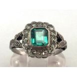 An Art Deco emerald and diamond cluster ring, the central emerald cut approx. 1.14 carats, in a