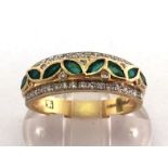 An 18 carat gold, diamond and emerald half hoop ring, with a central band of small rub over set