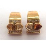 A pair of diamond and citrine ear studs, rub over set with two tones of triangular cabochon cut