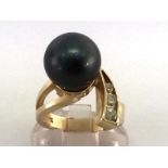 A cultured Tahitian black pearl and diamond ring, the obliquely set round black pearl 12.4mm, with a