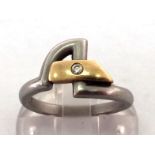 A platinum and diamond ring, the bezel of asymmetric anvil design, rub over set to the centre with a