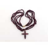 A garnet cross pendant, the foil backed table cut garnets claw set within a yellow metal mount, 3.