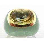 A citrine and jade ring, the central rectangular mixed cut stone 9.6 x 3.1mm, closed back, within